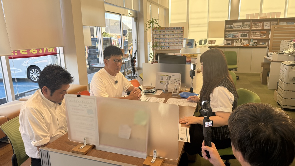 店内で車の買い方や見積もりについて撮影している様子